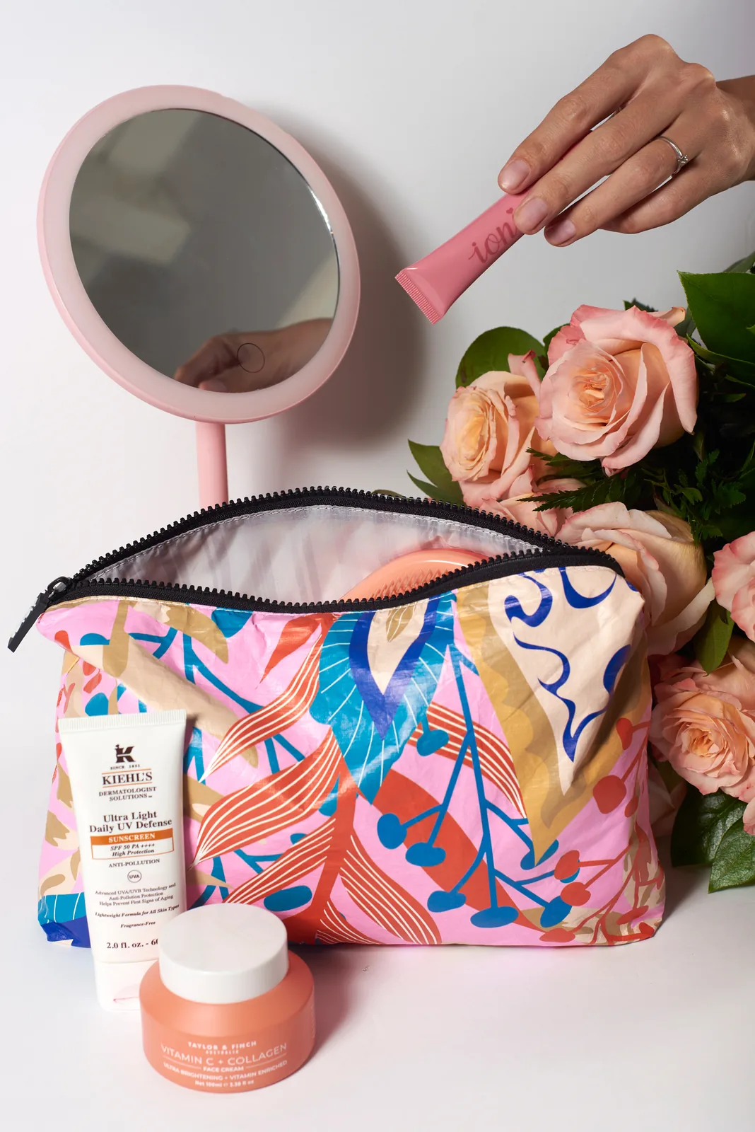 Printed cosmetic bag styled with a mirror and roses