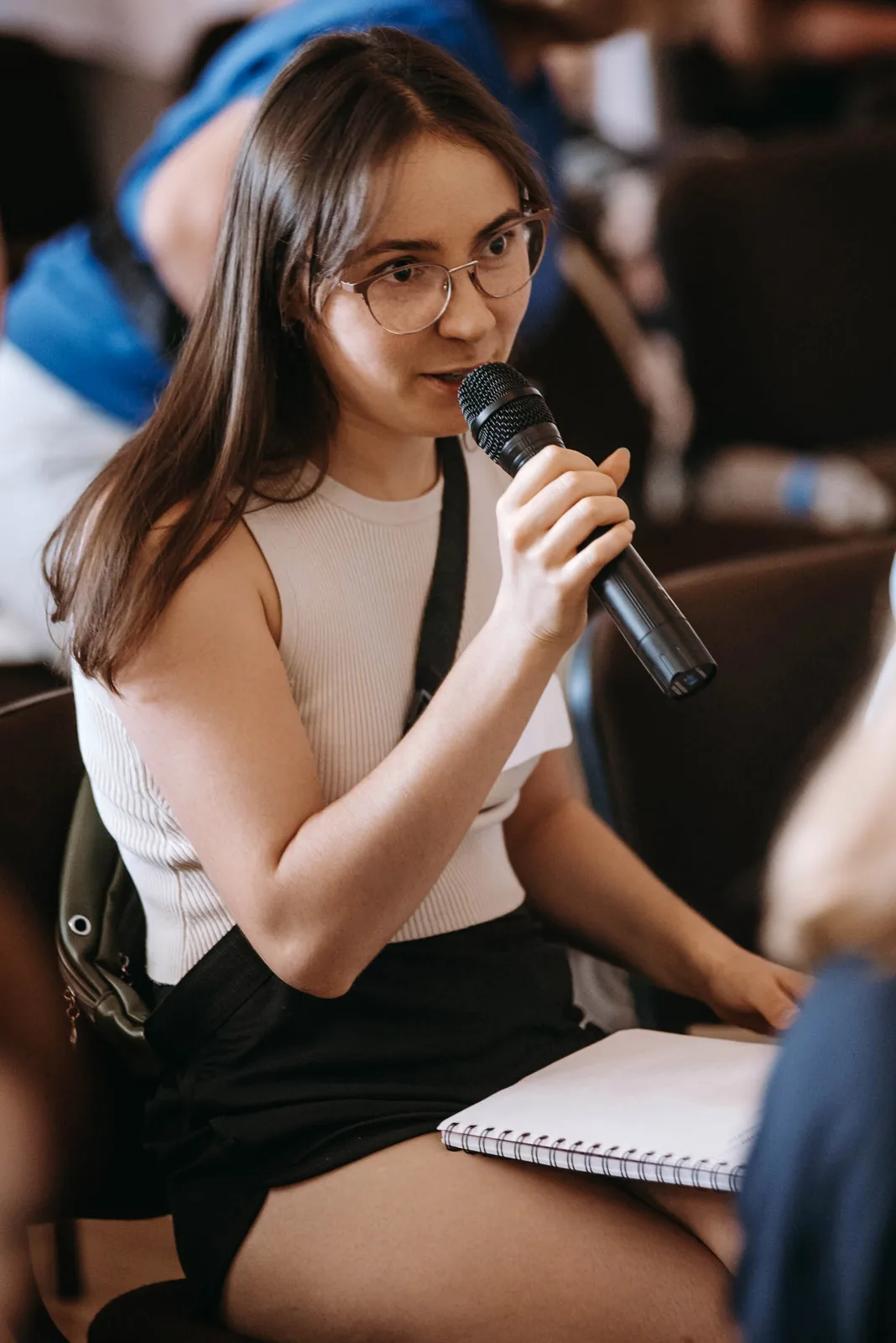 Attendee asking a question into a microphone at a forum