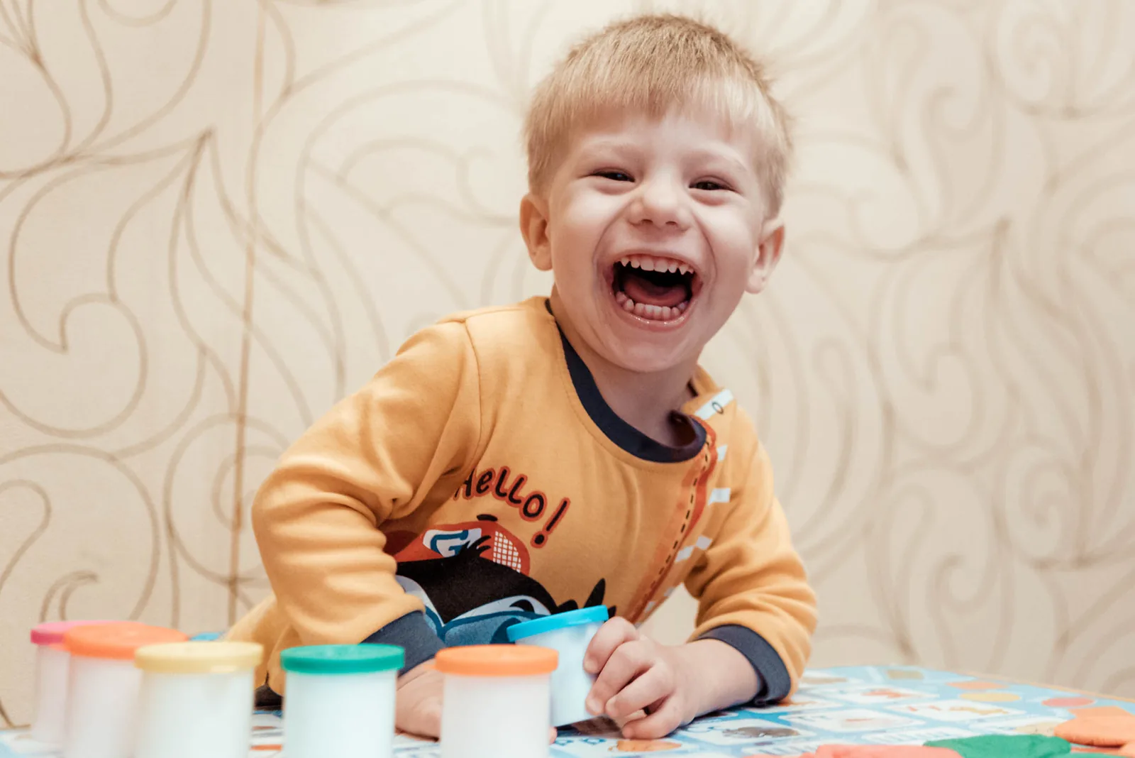 Laughing toddler at his second birthday party with balloons