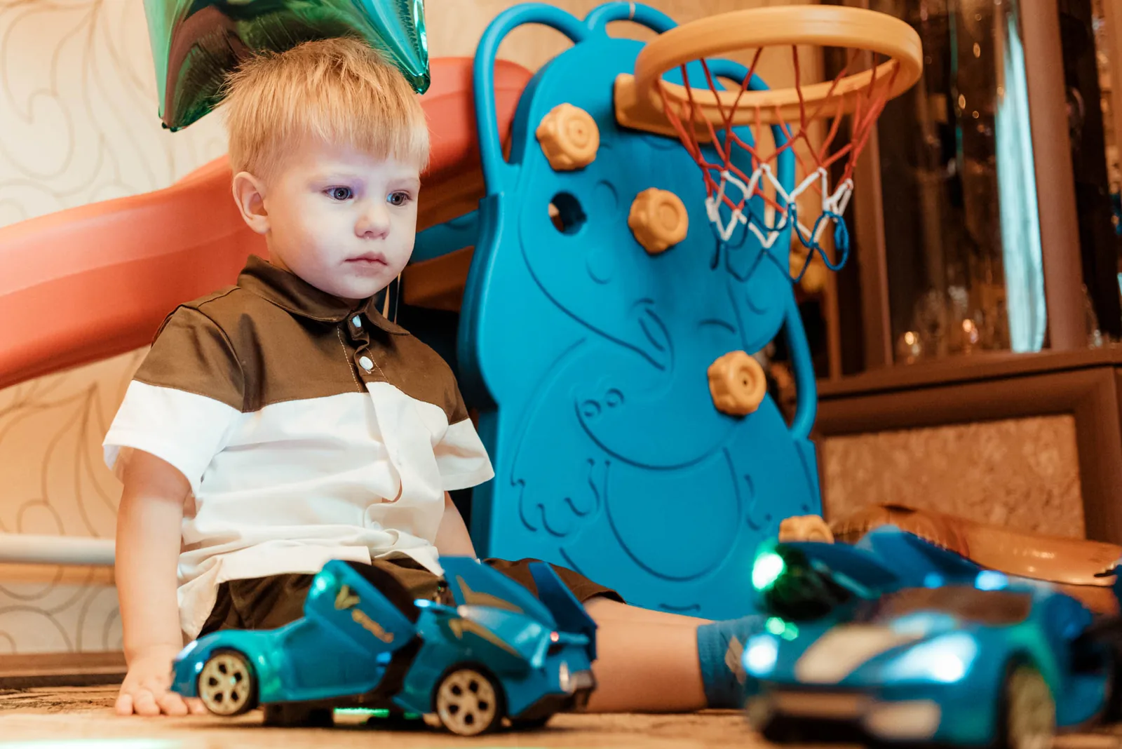 Toddler playing with new toy cars at his birthday party