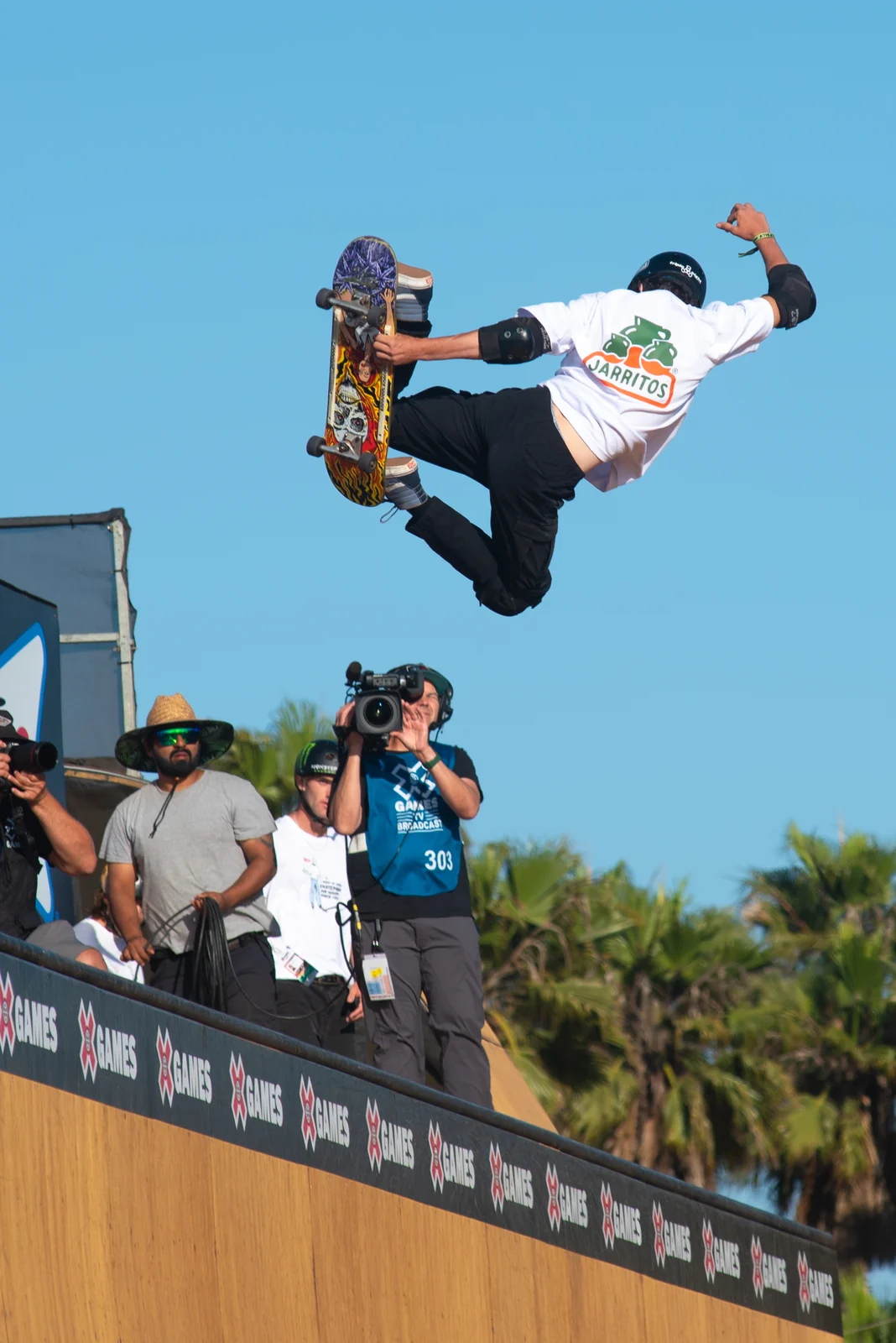 Skater flying over the vert ramp against blue sky