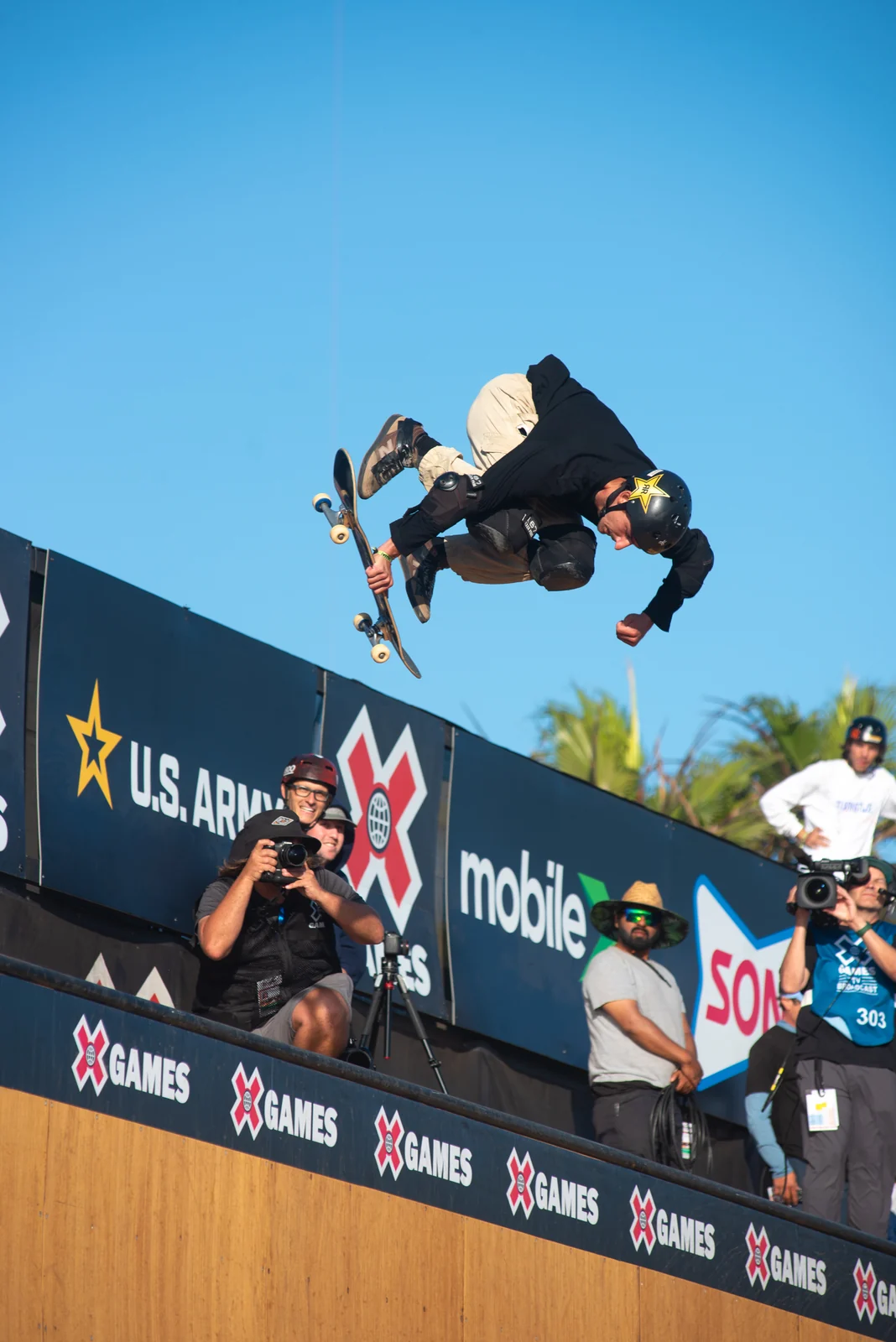 Skater above the ramp with sponsor banners