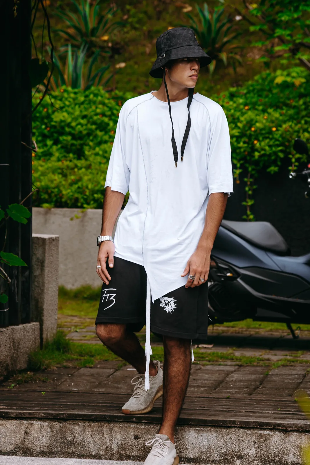 Male model in oversized streetwear outfit, tropical setting