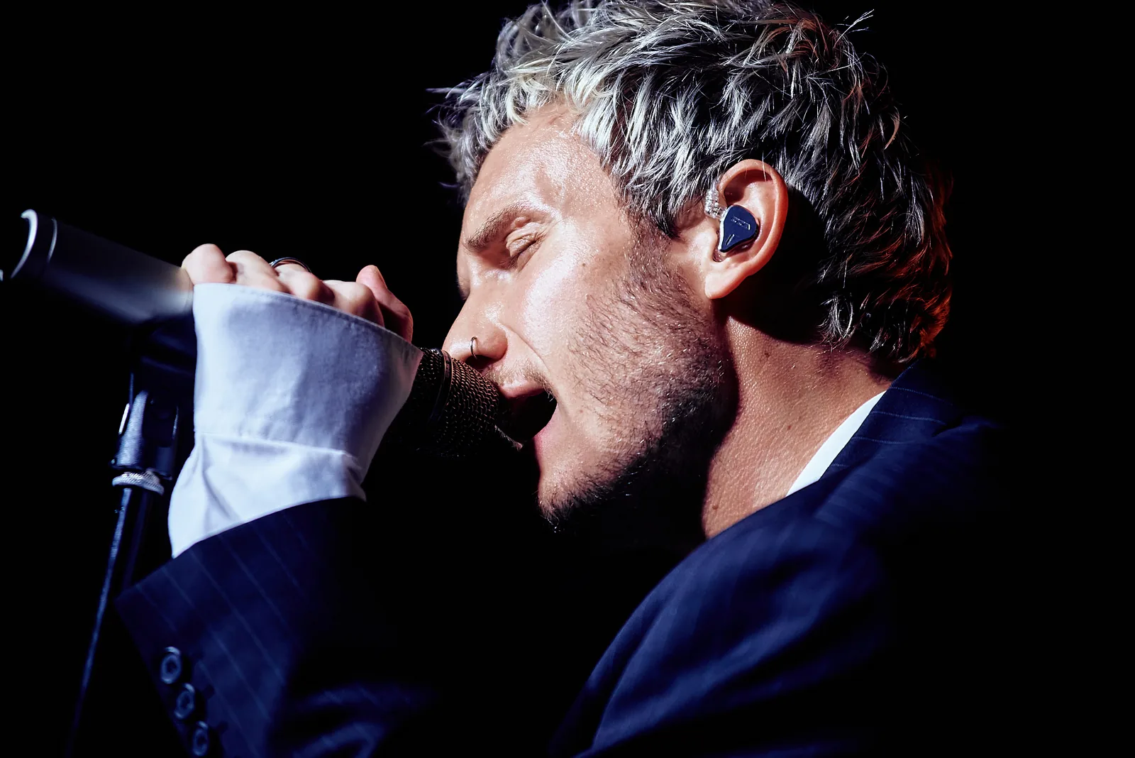 Close-up of a singer at the microphone, dramatic side light