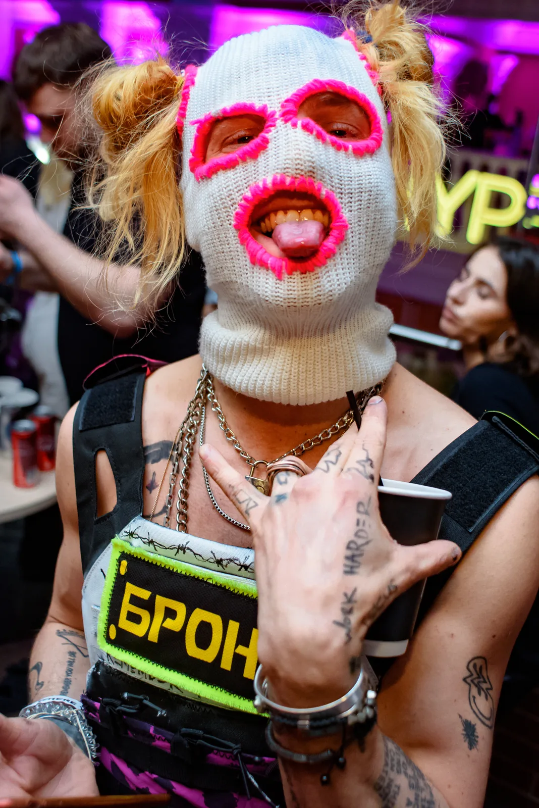 Performer in a pink balaclava mask posing with attitude