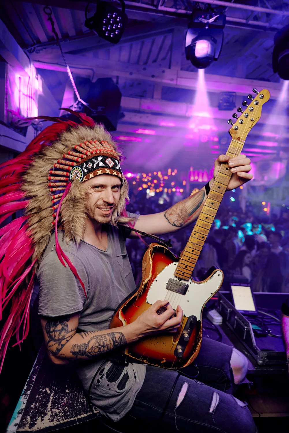 Guitarist in a feather headdress on stage