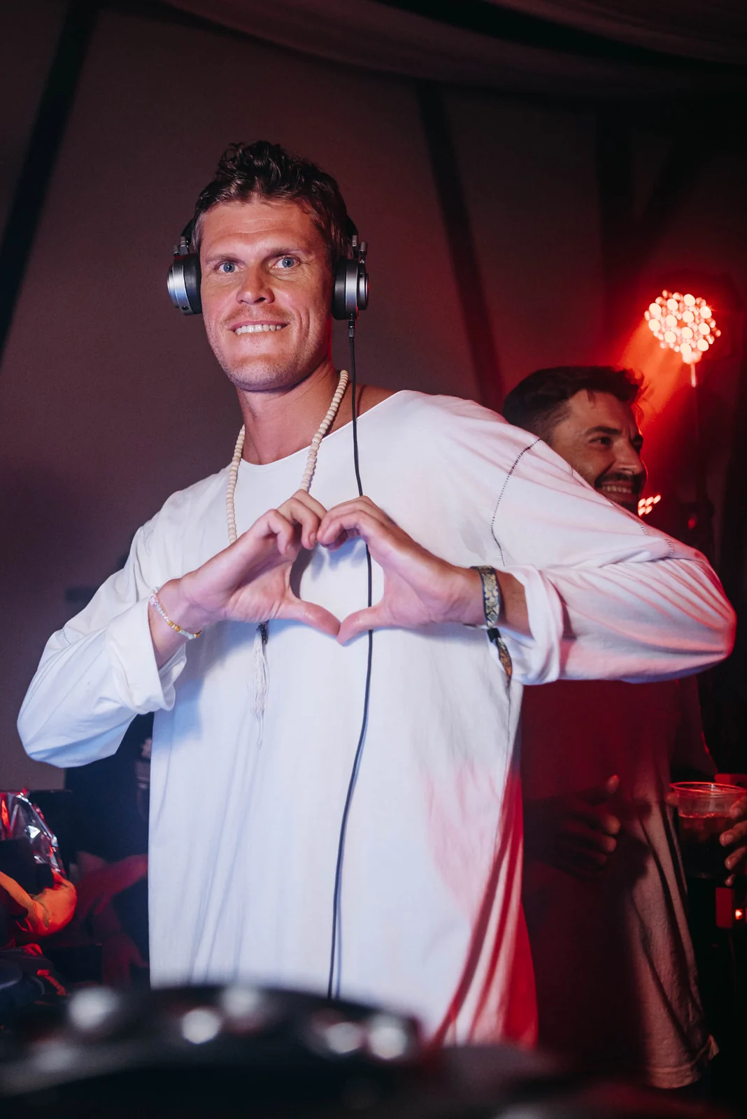 DJ in a white shirt making a heart sign