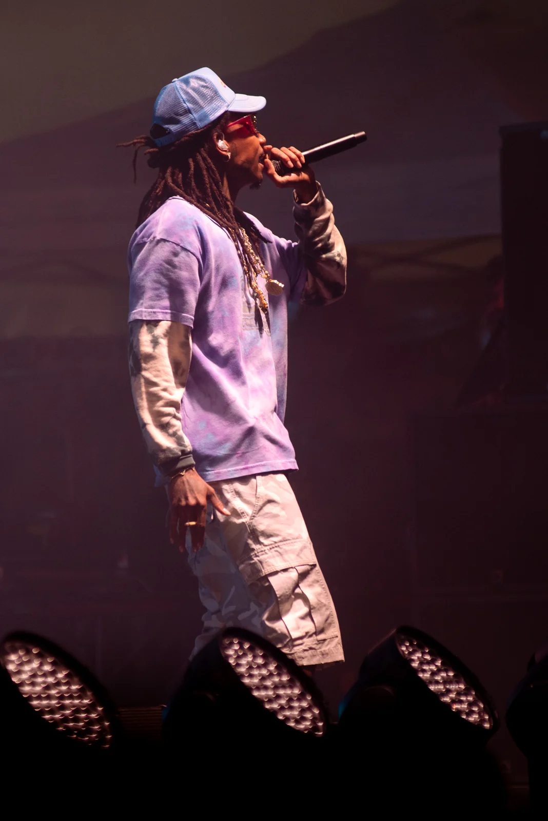 Rapper performing under purple stage light