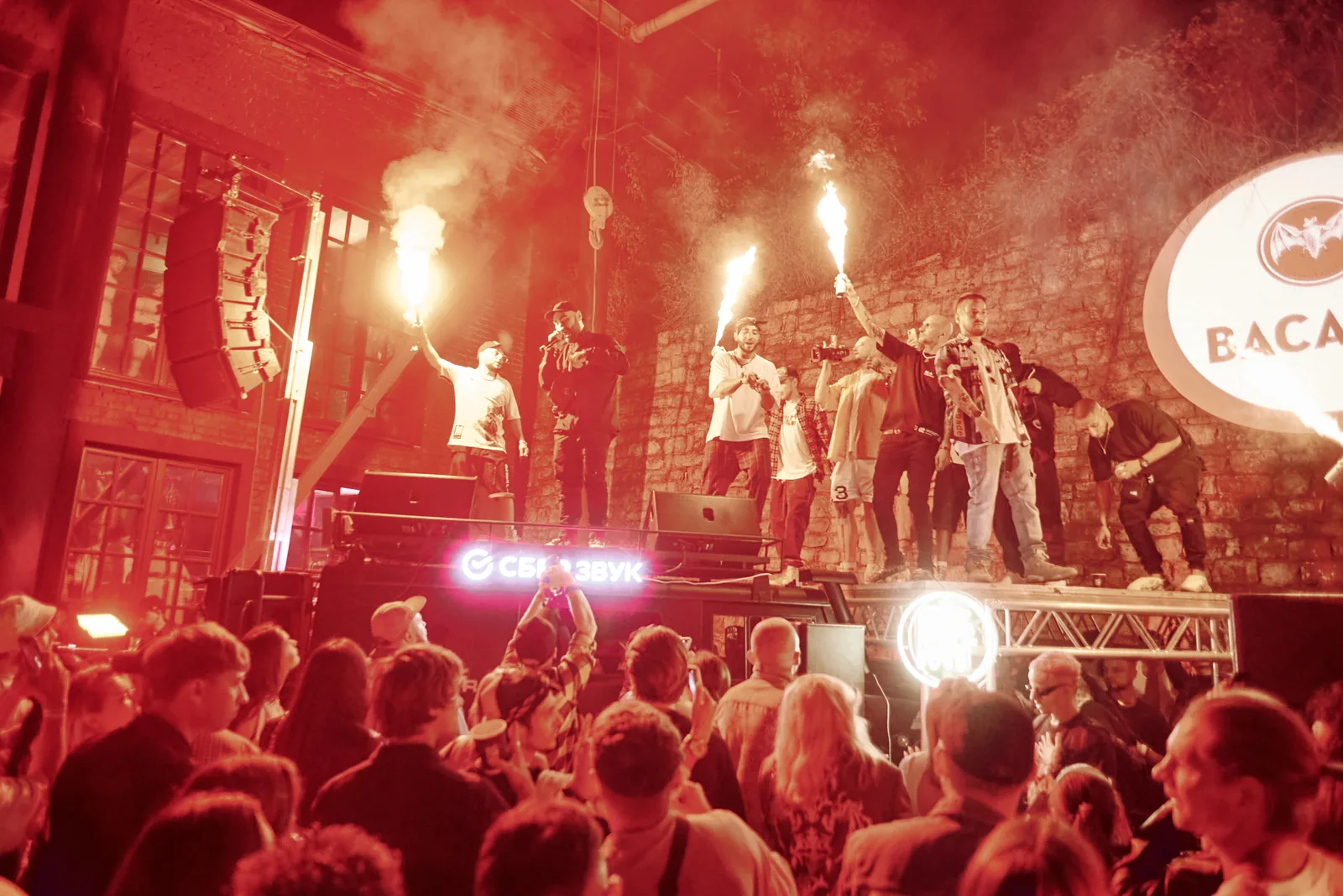 Fire show performers lighting up a packed club stage