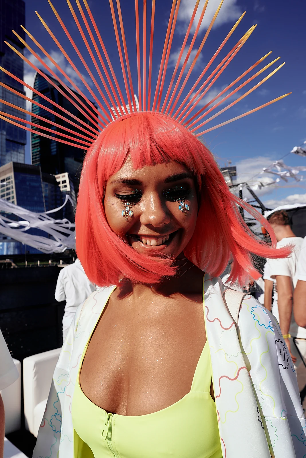Guest with neon pink hair and sunburst headpiece at a white party