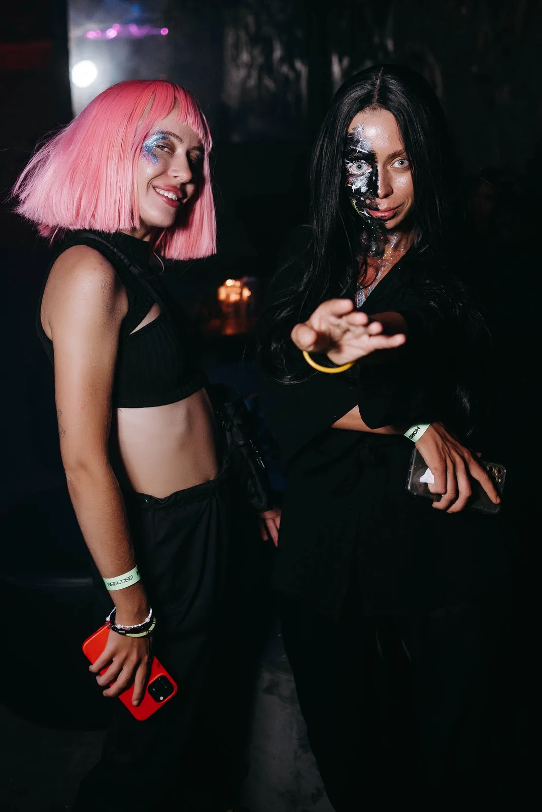 Two friends, one in a pink wig, posing at a club