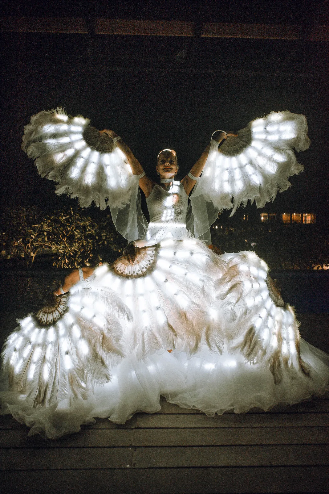 Performer with glowing LED wings at a New Year's Eve party