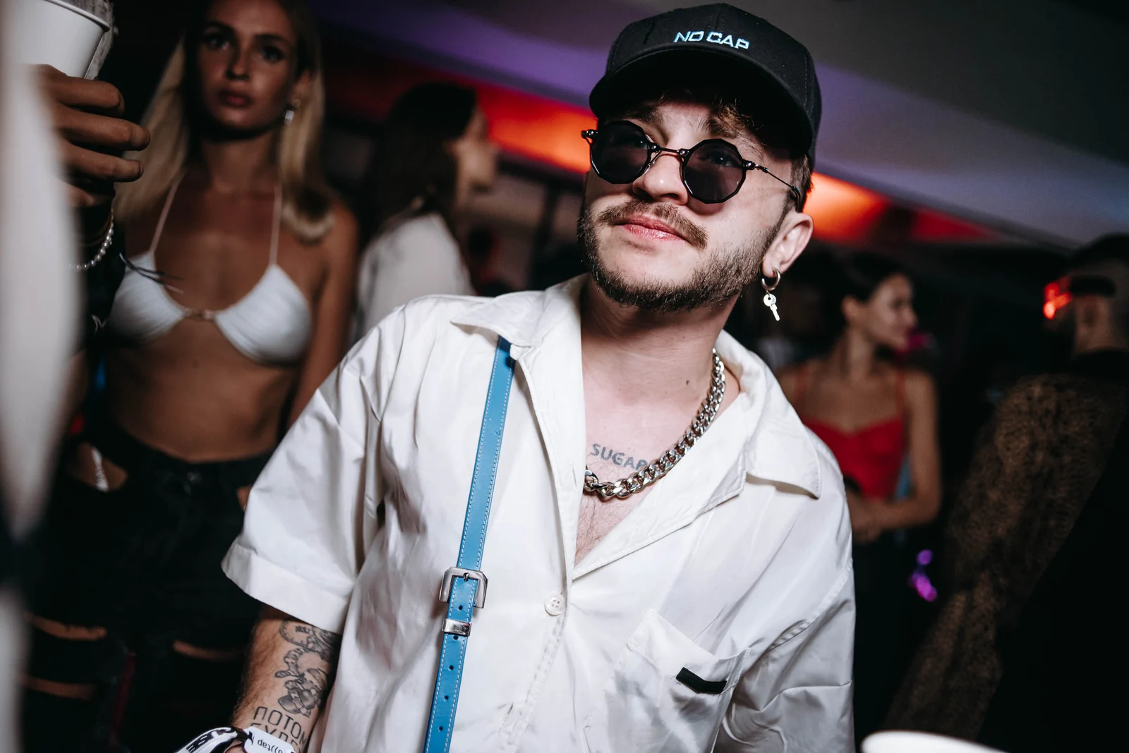 Guest in a white shirt and sunglasses at a club