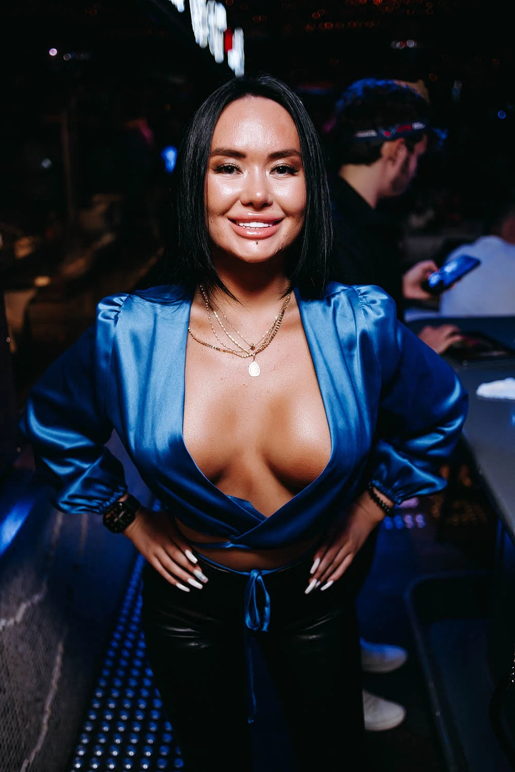 Woman in a blue satin top at a party