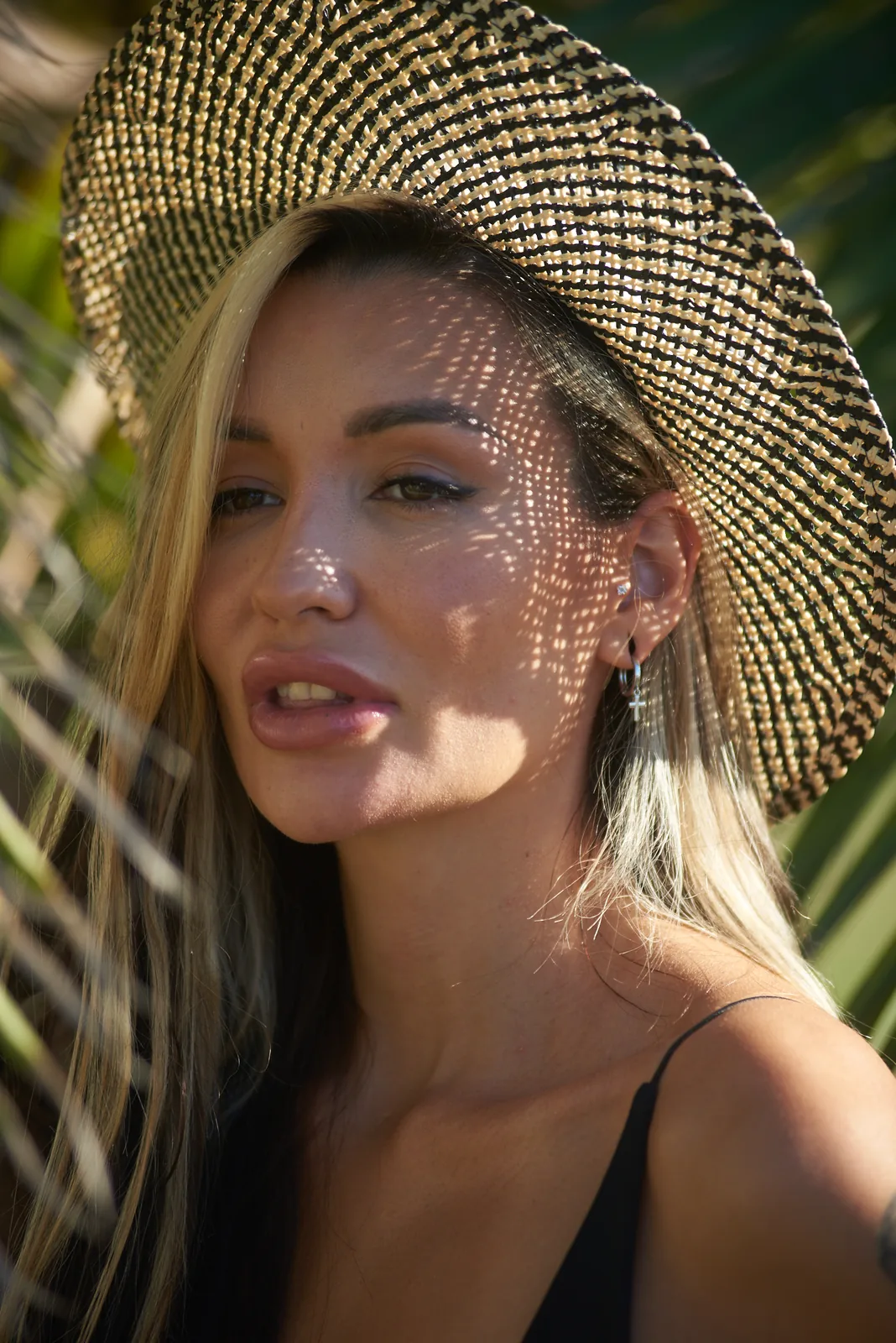 Close-up portrait of a woman in a straw hat with glitter freckles