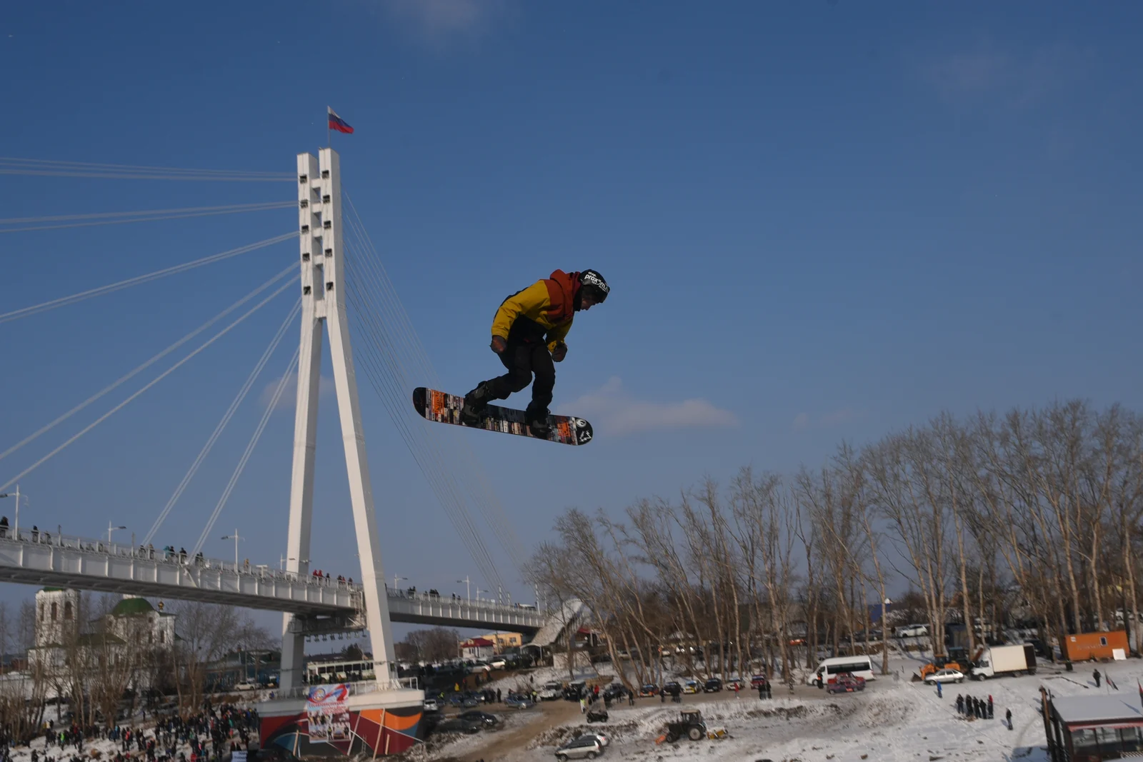 Snowboarder flying above the river bridge