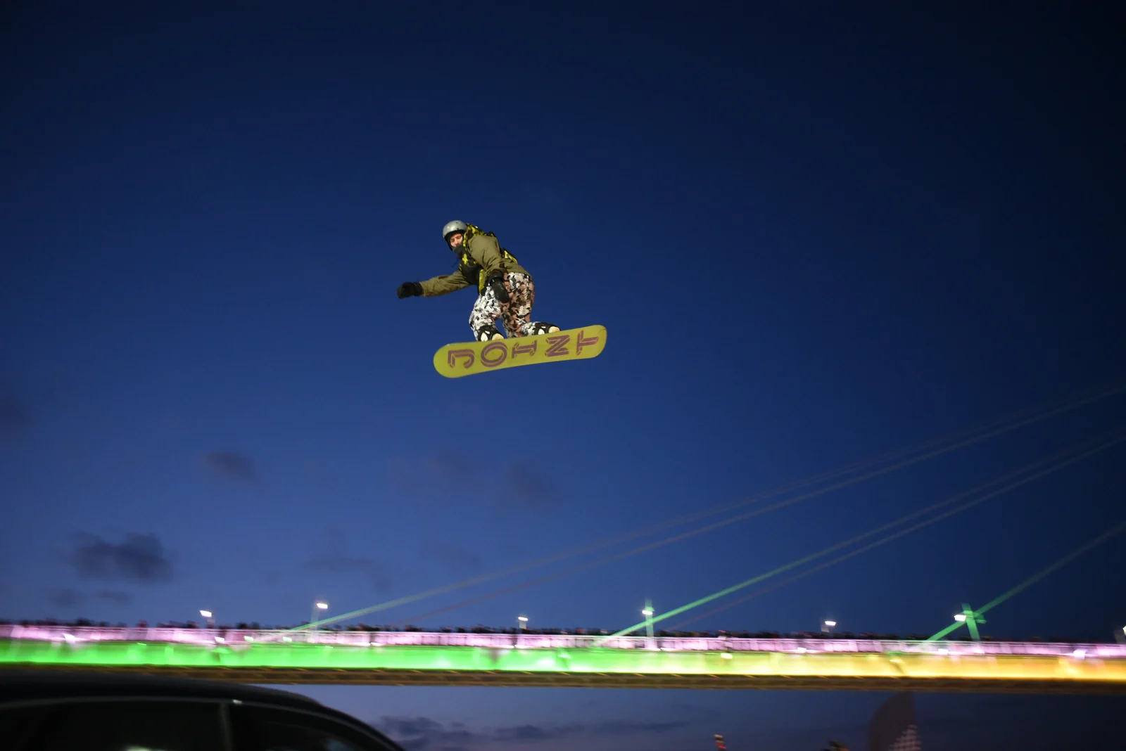 Snowboarder in the air at night over the kicker