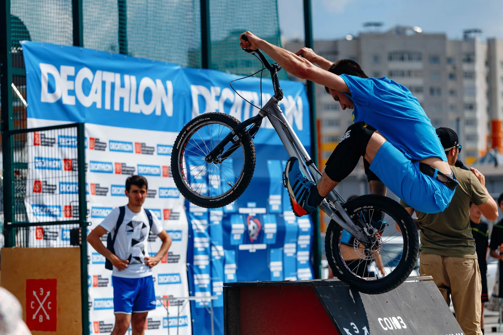 BMX rider on the back wheel by the store wall