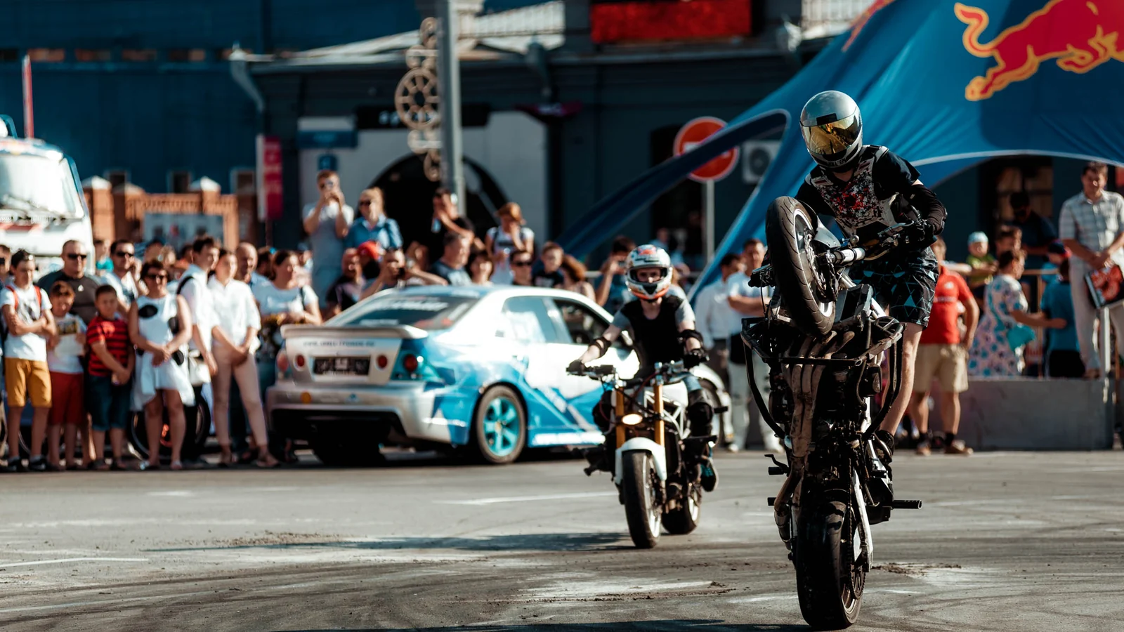 Motorcycle stunt rider wheelie in front of the crowd